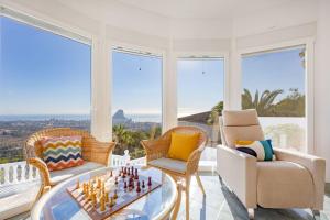 salon z szachownicą na szklanym stole w obiekcie Villa Lehman - PlusHolidays w mieście Calpe
