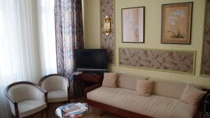 a living room with a couch and a tv at Hotel Kutscherstube in Lüneburg