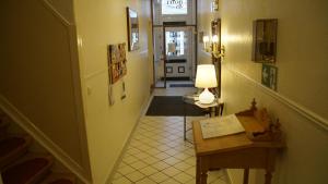 a hallway with a stairway with a table and a lamp at Hotel Kutscherstube in Lüneburg