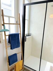 a bathroom with a ladder and blue towels at Appartement cosy au cœur de Saint Quentin in Saint-Quentin