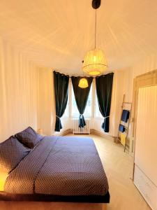 a bedroom with a bed and a large window at Appartement cosy au cœur de Saint Quentin in Saint-Quentin
