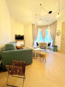 a living room with a green couch and a table at Appartement cosy au cœur de Saint Quentin in Saint-Quentin