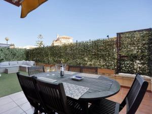 Una mesa negra con sillas y una botella de vino. en Arrecife Home by Staycare, en Rota