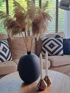 a black vase sitting on a table with two spoons at Villa Present - Vakantiewoning Herkingen in Herkingen