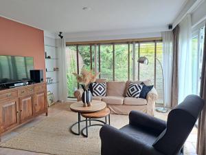 a living room with a couch and a table at Villa Present - Vakantiewoning Herkingen in Herkingen