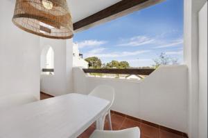 ein weißes Esszimmer mit einem weißen Tisch und Stühlen in der Unterkunft Isla Candor free parking by Staycare in Rota