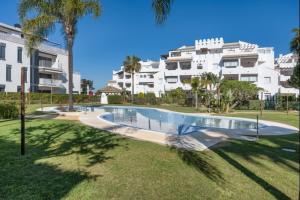 einen Pool in einem Garten vor einem Gebäude in der Unterkunft Isla Candor free parking by Staycare in Rota