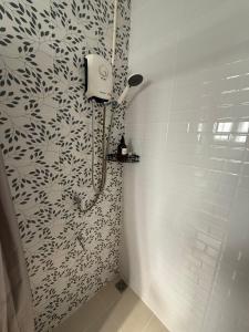 a bathroom with a shower with a black and white pattern at Charma Home Watket in Chiang Mai