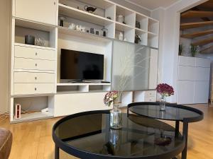 a living room with a glass table and a tv at Großzügige, zentrale Ferienwohnung in Leer in Leer
