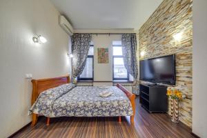 a small room with a bed and a flat screen tv at Park Lane Inn Apartament Lebedeva in Saint Petersburg