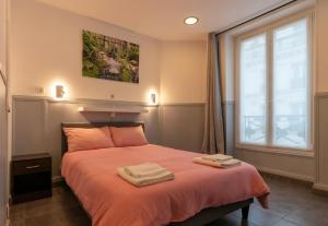 a bedroom with a bed with two towels on it at Hotel Geoffroy Marie Opéra in Paris