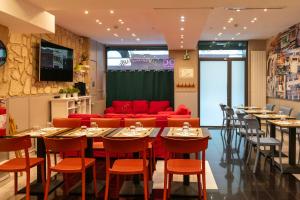 a restaurant with tables and chairs and a red couch at Hotel Geoffroy Marie Opéra in Paris