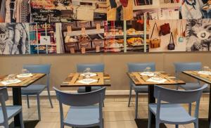 a restaurant with wooden tables and blue chairs at Hotel Geoffroy Marie Opéra in Paris
