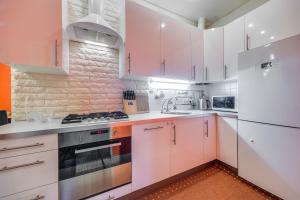 a kitchen with white cabinets and a white refrigerator at Park Lane Inn Apartament Lebedeva in Saint Petersburg