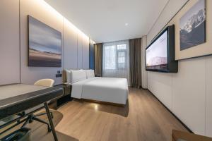 a hotel room with a bed and a tv at Atour Hotel Beijing Zhongguancun Renmin University in Beijing