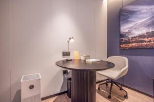 a room with a table and a chair and a painting at Atour Hotel Beijing Zhongguancun Renmin University in Beijing