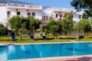 a hotel with a swimming pool in front of a building at Captain Tom in Frangokastello