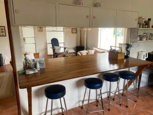 a kitchen with a large wooden counter with stools at lagoon value ! in Langebaan