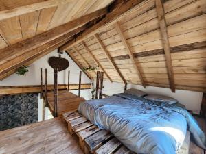 ル・ティヨにあるChalet de la Comtéの木製天井の客室の大型ベッド1台分です。