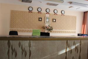 a reception desk with clocks on the wall at Ust-Kamenogorsk Hotel in Ustʼ-Kamenogorsk