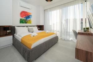 a bedroom with a large bed with a yellow blanket at Elegant Villa Cataleya with private pool and sauna in Novalja +62 photos