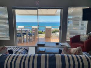 ein Wohnzimmer mit Sofas und Meerblick in der Unterkunft Sunset Bliss - Gansbaai Seafront Accommodation in Gansbaai