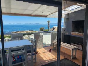 ein Haus mit Balkon mit Blick auf das Meer in der Unterkunft Sunset Bliss - Gansbaai Seafront Accommodation in Gansbaai