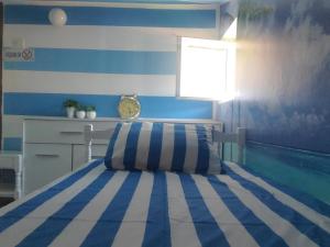 a bedroom with a bed with blue and white stripes at Guest House Olga in Budva