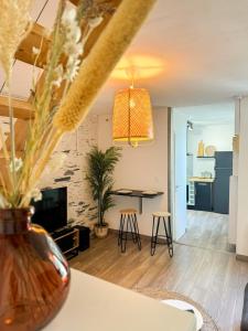 a living room with a table and a vase with flowers at Charmant Duplex Lumineux in Angers