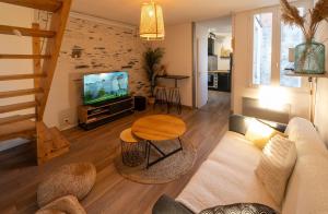 a living room with a couch and a table at Charmant Duplex Lumineux in Angers
