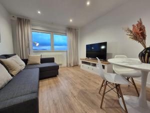 a living room with a couch and a table and a tv at C01A07 Moderno apartamento con vistas in Santander
