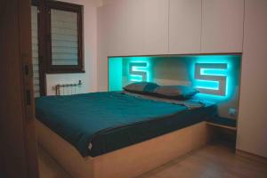 a bedroom with a bed with neon lights on it at Luxury S&S panoramic city view apartment in Skopje