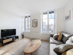 a living room with a couch and a table at Escapade parfaite 4 pers Hypercentre Blatin in Clermont-Ferrand +10 photos