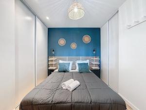 a bedroom with a large bed with a blue wall at Escapade parfaite 4 pers Hypercentre Blatin in Clermont-Ferrand