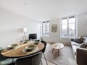 a living room with a table and a couch at Escapade parfaite 4 pers Hypercentre Blatin in Clermont-Ferrand