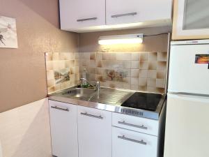 a small kitchen with a sink and a refrigerator at Studio le romantique à 20 kms de Nice in Bendéjun