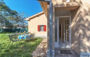 a house with a table and chairs in the yard at Holiday Home Kature Iv in Labin