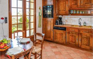 a kitchen with wooden cabinets and a table and chairs at Amazing Home In Bassillac-Et-Auberoche in Le Change