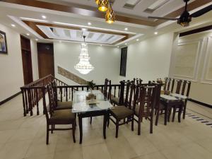 a dining room with a table and chairs and a chandelier at AL Fateh Hotel in Lahore +57 photos