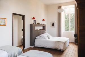 una camera da letto con due letti e una finestra di La Maison D'Olivier a Mesnard-la-Barotière Altre 124 foto