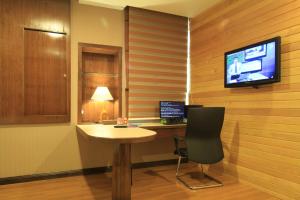 a room with a table and a television and a chair at Ming Paragon Hotel in Kuala Terengganu