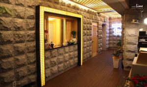 a hallway with a mirror on a brick wall at Jeonju Lime Hotel in Jeonju