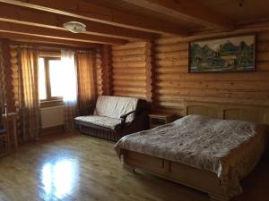 a bedroom with a bed and a chair in a cabin at Privatna Sadiba Chalet in Oryavchyk +50 photos