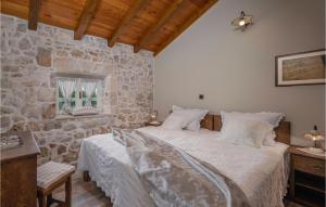 Un dormitorio con una cama y una pared de piedra. en Villa Jerolim, en Zadar