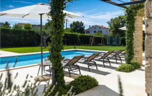un groupe de chaises et un parasol à côté d'une piscine dans l'établissement Villa San Martino, à Rovinj