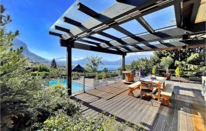 eine Terrasse mit einem Tisch und Stühlen auf einer Holzterrasse in der Unterkunft La Maison Du Bonheur in Veyrier-du-Lac