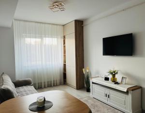a living room with a table and a tv at Adam Home Ap in Fălticeni