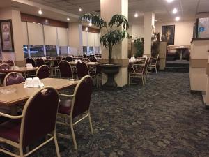a restaurant with tables and chairs in a room at St. Albert Inn & Suites in St. Albert