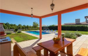 een terras met een tafel en een zwembad bij Villa Rebici in Pula