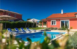 een zwembad met blauwe stoelen en een huis bij Villa Rebici in Pula